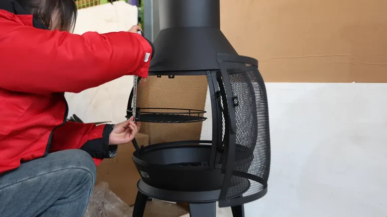 Quality control worker checking assembly of an outdoor fireplace